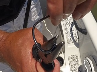 Making a hook barbless by using pliers to crimp down the barb